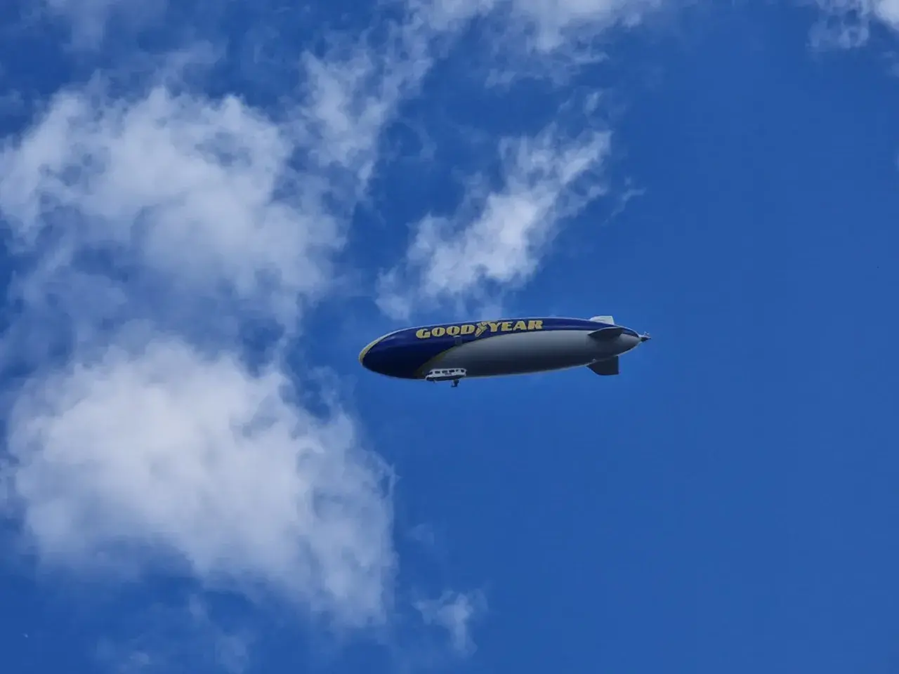 Ein Goodyear-Zeppelin schwebt am blauen Himmel. Wie viele Zeppeline es gibt, ist unklar, aber dieser hier ist gut sichtbar.