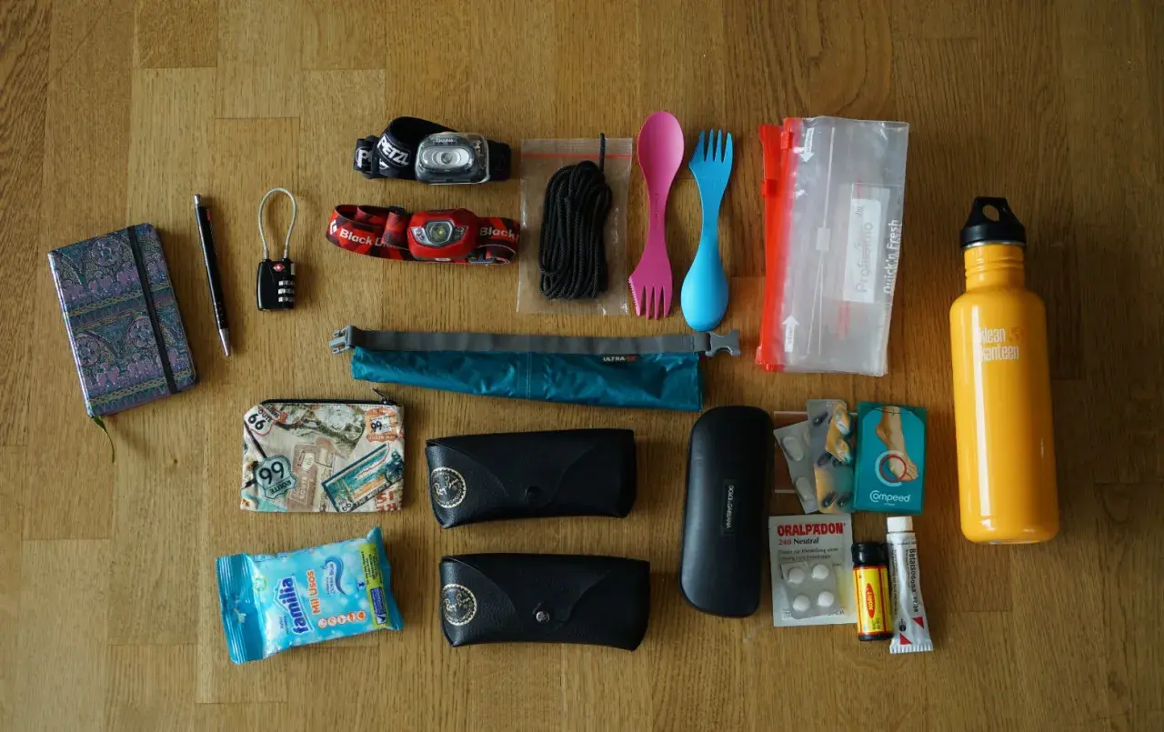 Packliste Jordanien: Notizbuch, Stift, Schloss, Stirnlampen, Seil, Besteck, Beutel, Brillenetuis, Sonnenbrille, Reiseapotheke, Wasserflasche.