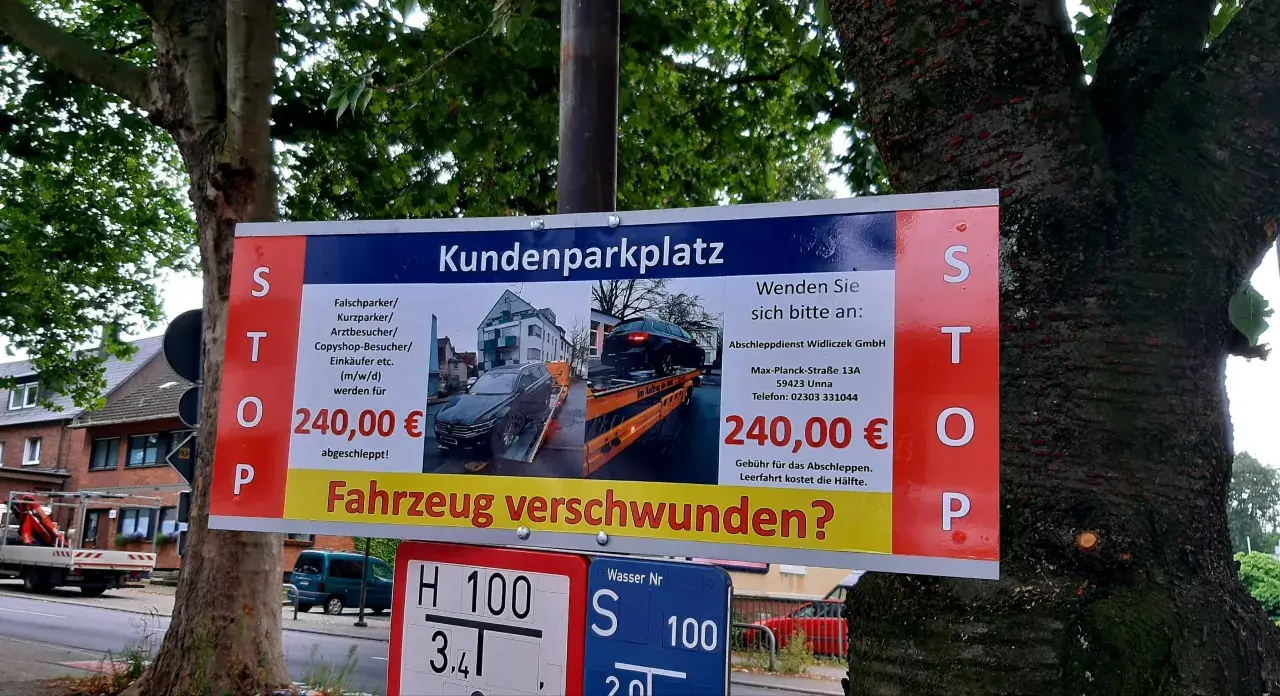 Schild warnt vor hohen **Abschleppkosten ohne Abschleppen** bei Falschparken auf Kundenparkplatz. 240€ Strafe!