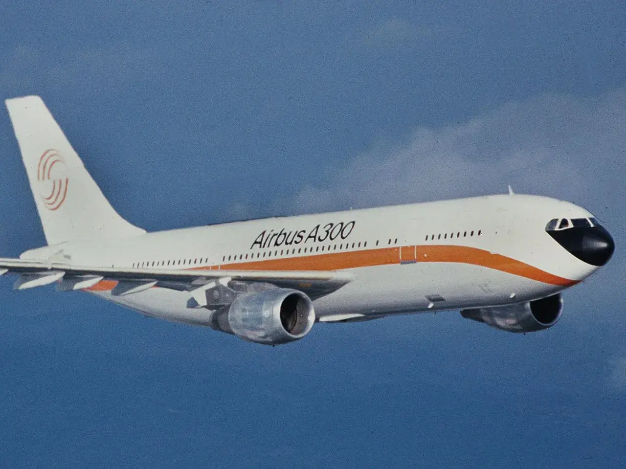 Ein Airbus A300 fliegt im blauen Himmel. Seit wann gibt es Flugzeuge? Diese Maschine ist ein Meilenstein der Luftfahrtgeschichte.