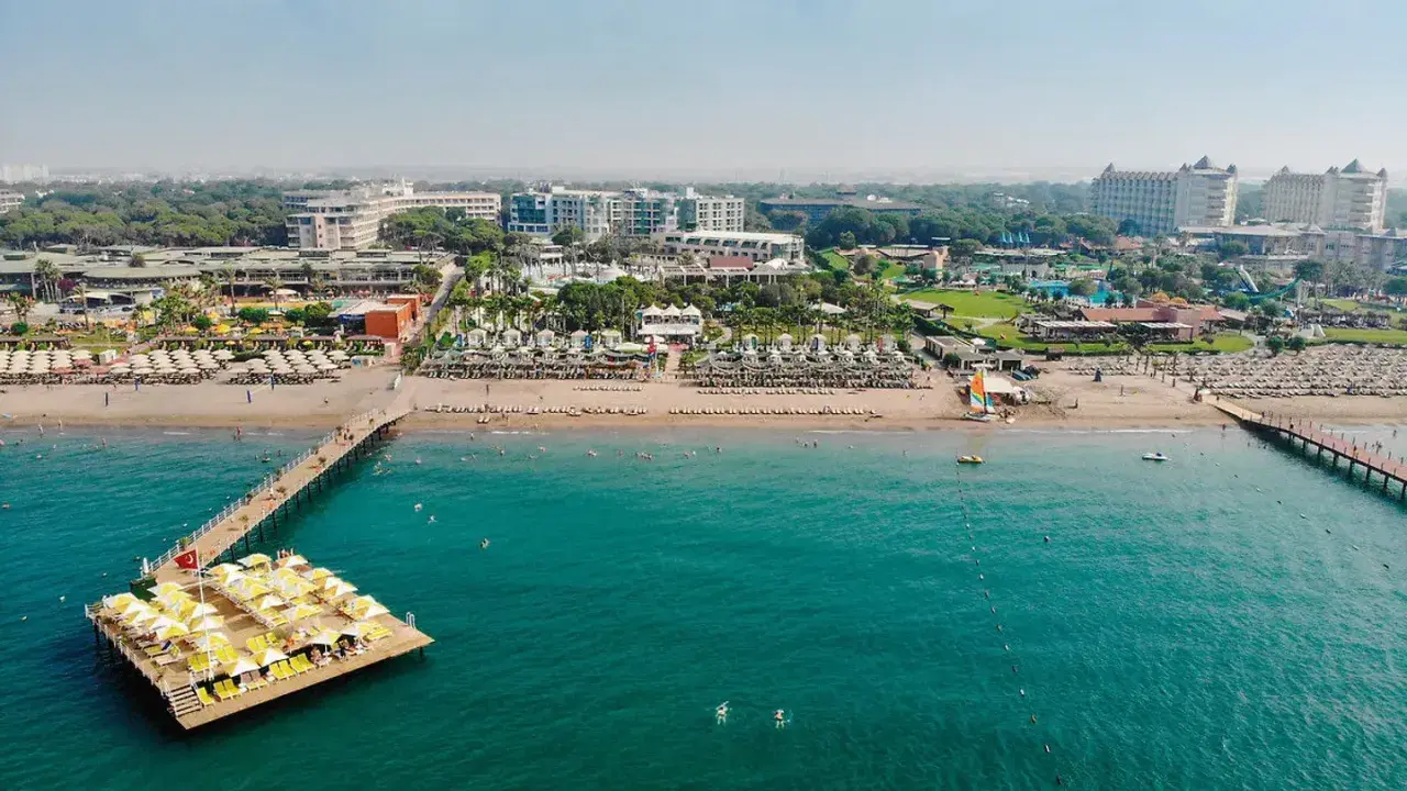Traumhafter Blick auf das Limak Atlantis De Luxe Hotel & Resort mit Strand, Steg und türkisfarbenem Meer.