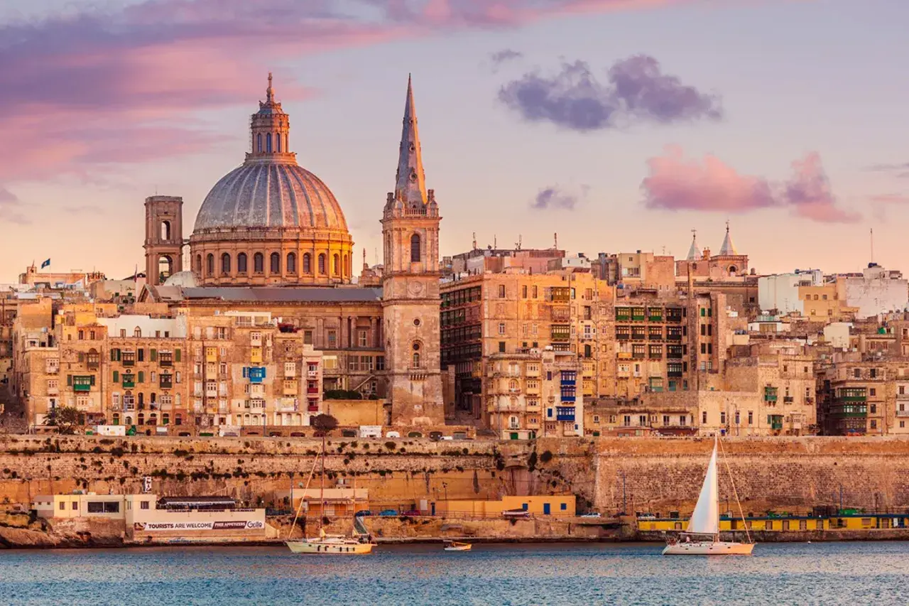 Sonnenuntergang über Valletta, Malta. Die Kuppel der St. Paul's Cathedral und die St. John's Co-Cathedral dominieren die Skyline. Ein perfekter Ort für einen Urlaub.