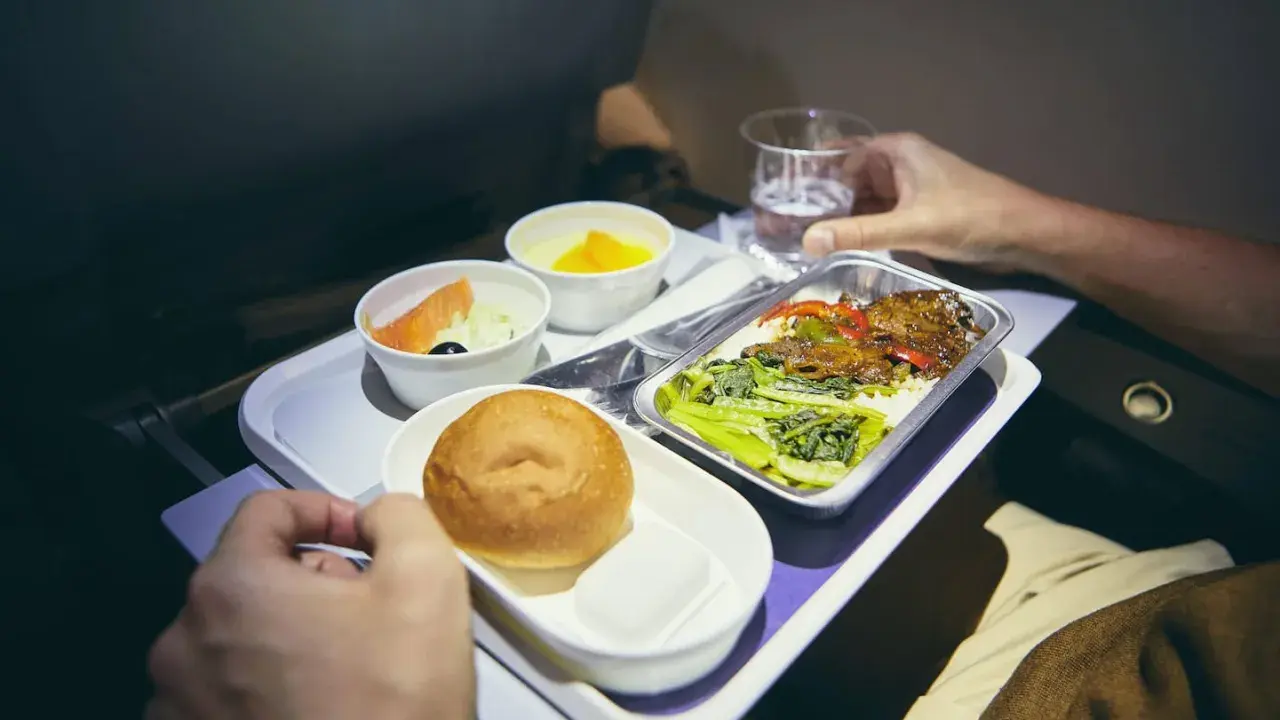 Flugzeugessen: Ab wann gibt es Essen? Ein Tablett mit Lachs, Brötchen, Dessert und Hauptgericht.