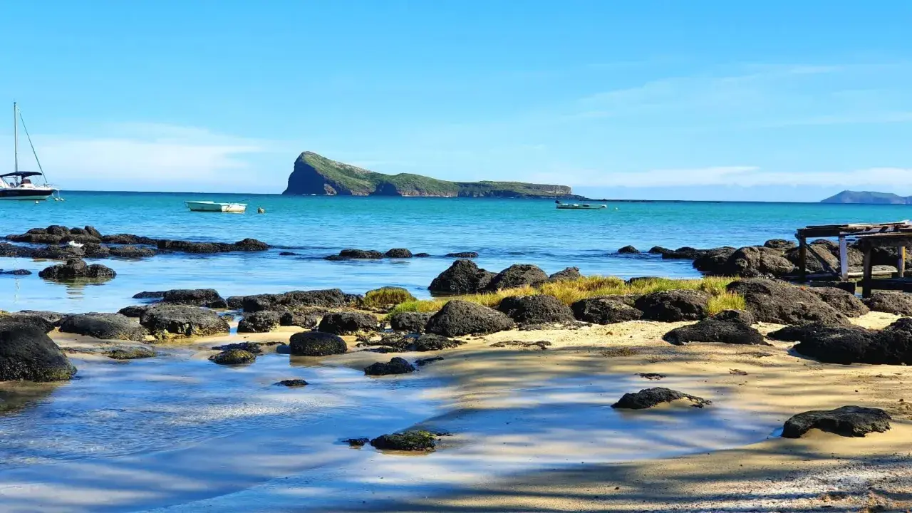 Traumhafte Küste mit Felsen und Booten. Die Mauritius Flugzeit ist es wert für diesen Anblick.