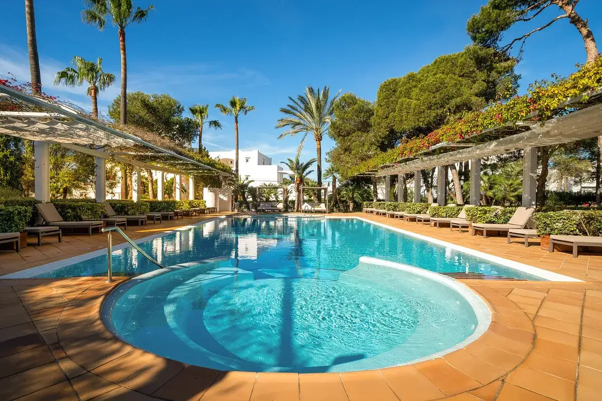 Entspannter Poolbereich mit Liegen und Palmen im Calimera Fido Gardens.
