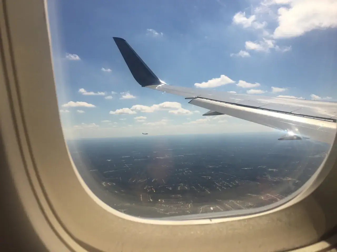 Blick aus dem Fenster eines Flugzeugs von Marabu Airlines. Ein weiteres Flugzeug fliegt in der Ferne.