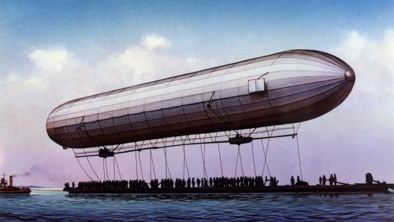 Ein riesiger Zeppelin schwebt &uuml;ber dem Wasser, wo Menschen auf einem langen Schiff warten. Das ist ein Zeugnis daf&uuml;r, was ist ein Zeppelin.