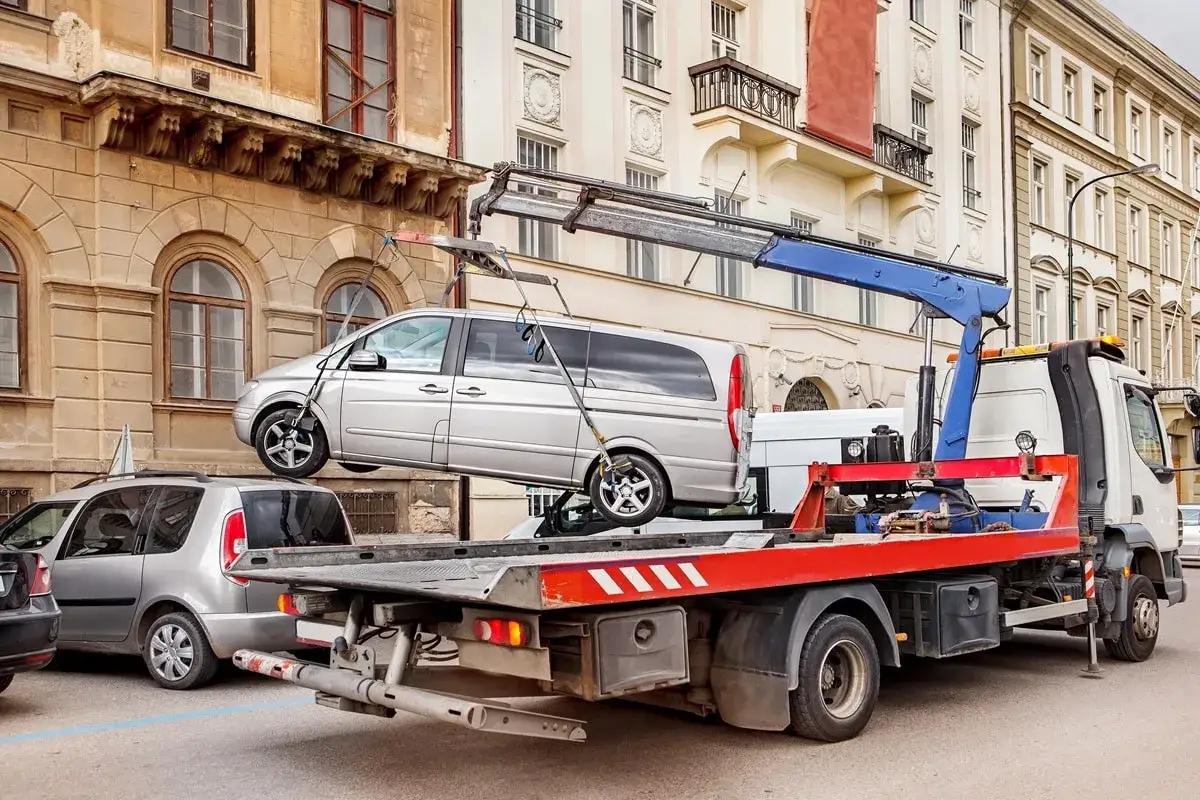 Abschleppwagen hebt silbernen Van an. Die Kosten pro Tag für das Abschleppen eines Autos können variieren.