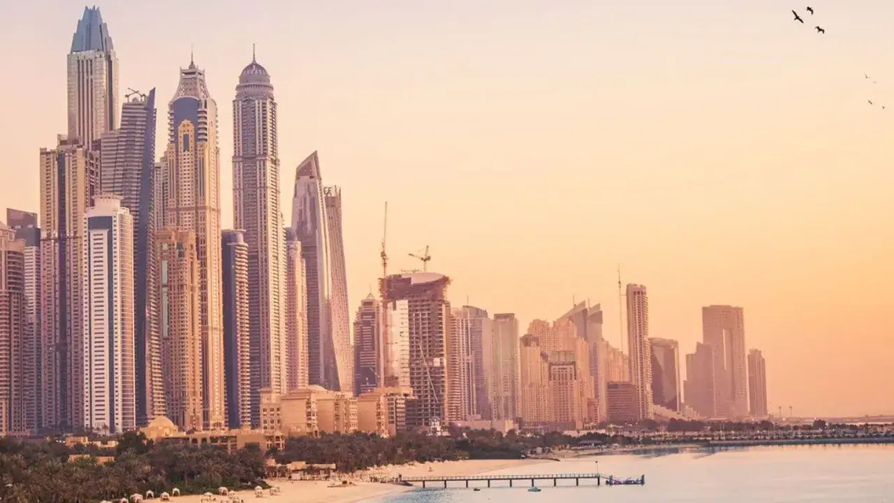 Sonnenuntergang über Dubais Skyline: Die beste Reisezeit für einen Strandurlaub mit Blick auf Wolkenkratzer.