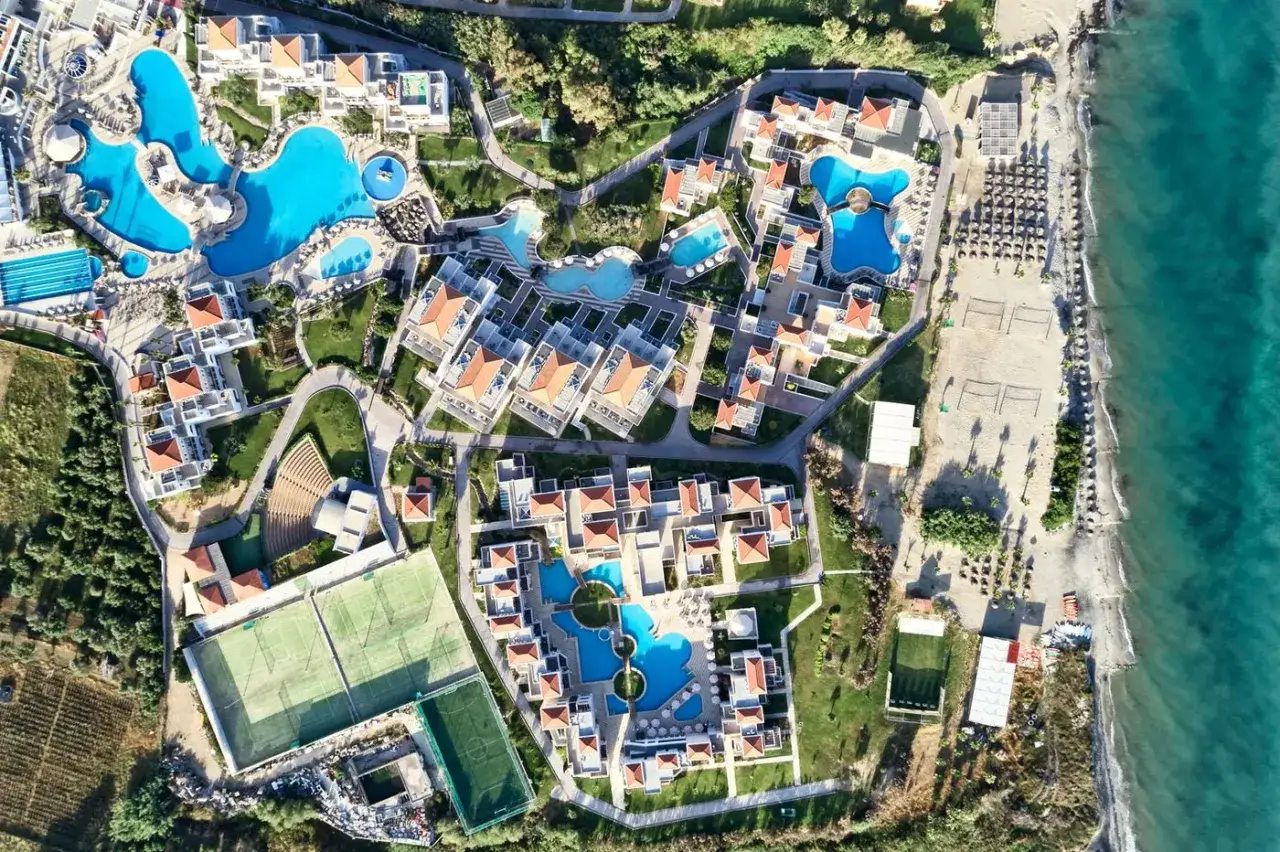 TUI Magic Life Marmari Palace: Luftaufnahme eines Resorts mit mehreren Pools, Tennisplätzen und Strandzugang am türkisfarbenen Meer.