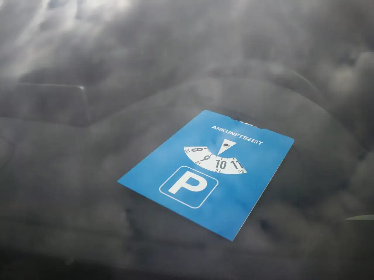 Blaue Parkscheibe mit Ankunftszeit-Einstellung, ein wichtiges Utensil für kostenloses Parken.