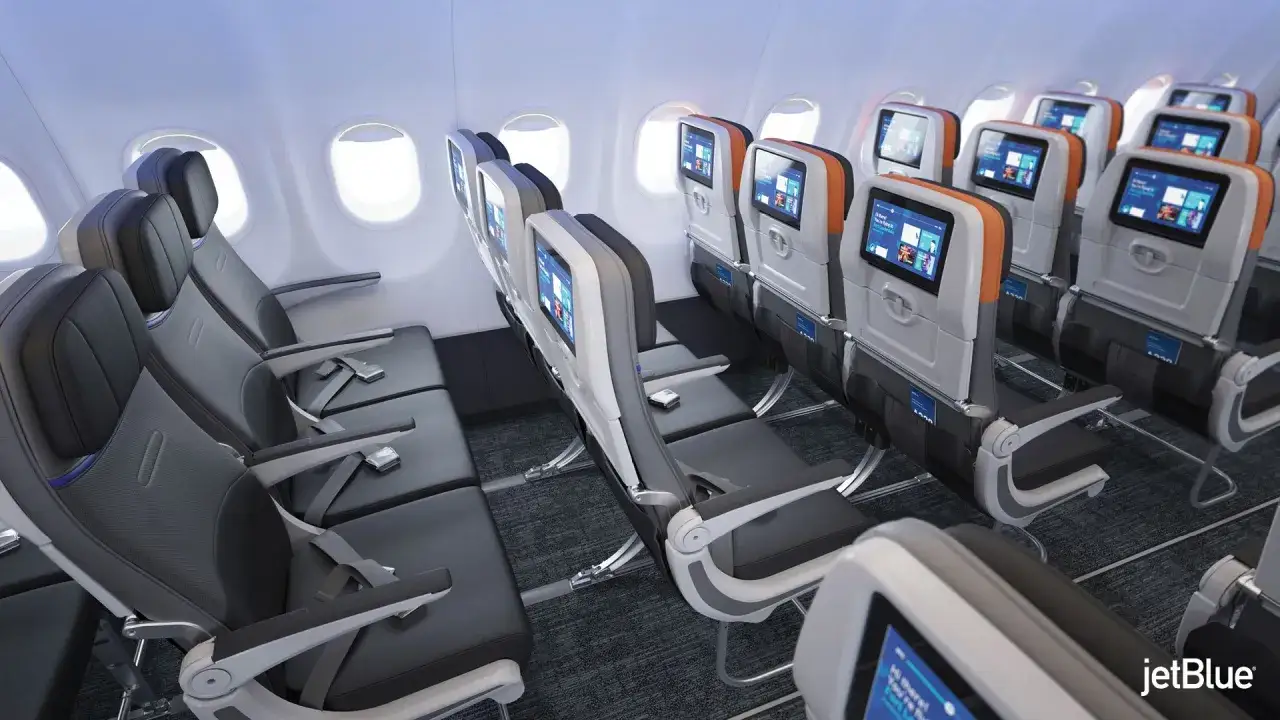 Innenansicht eines Airbus A320 mit modernen Sitzen und Bildschirmen.