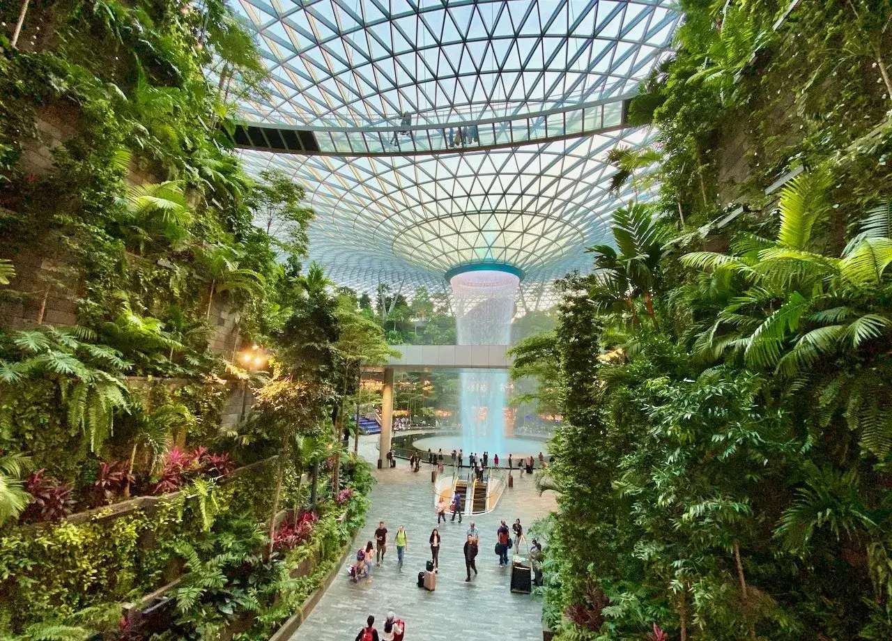 Imposanter Wasserfall im tropischen Garten des Flughafens Singapur. Ein grünes Paradies unter Glas.