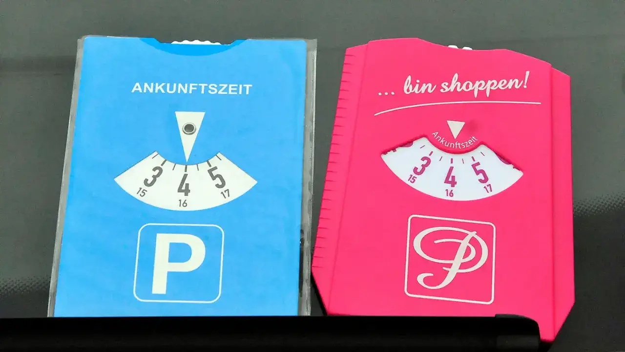 Zwei Parkscheiben, eine blaue und eine pinke, zeigen die Ankunftszeit an. Perfekt für parken mit parkscheibe nach 18 Uhr.