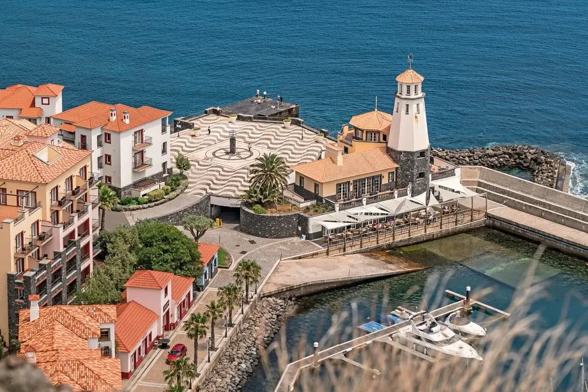 Traumhafte Aussicht auf Madeira: Spa & Marina mit Leuchtturm, Yachten und malerischen H&auml;usern am Meer.