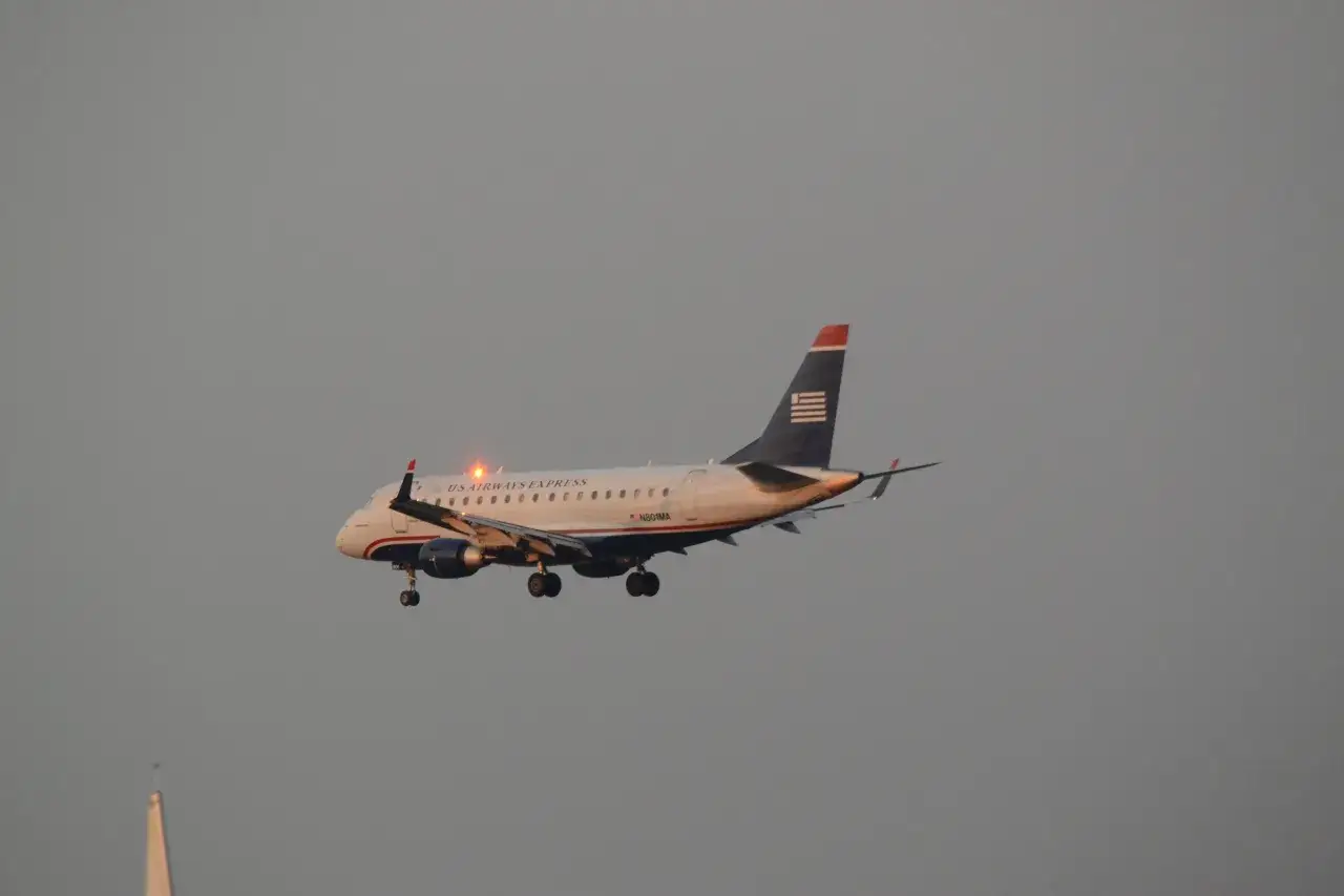 Ein US Airways Express Flugzeug mit ausgefahrenem Fahrwerk ist im Landeanflug.