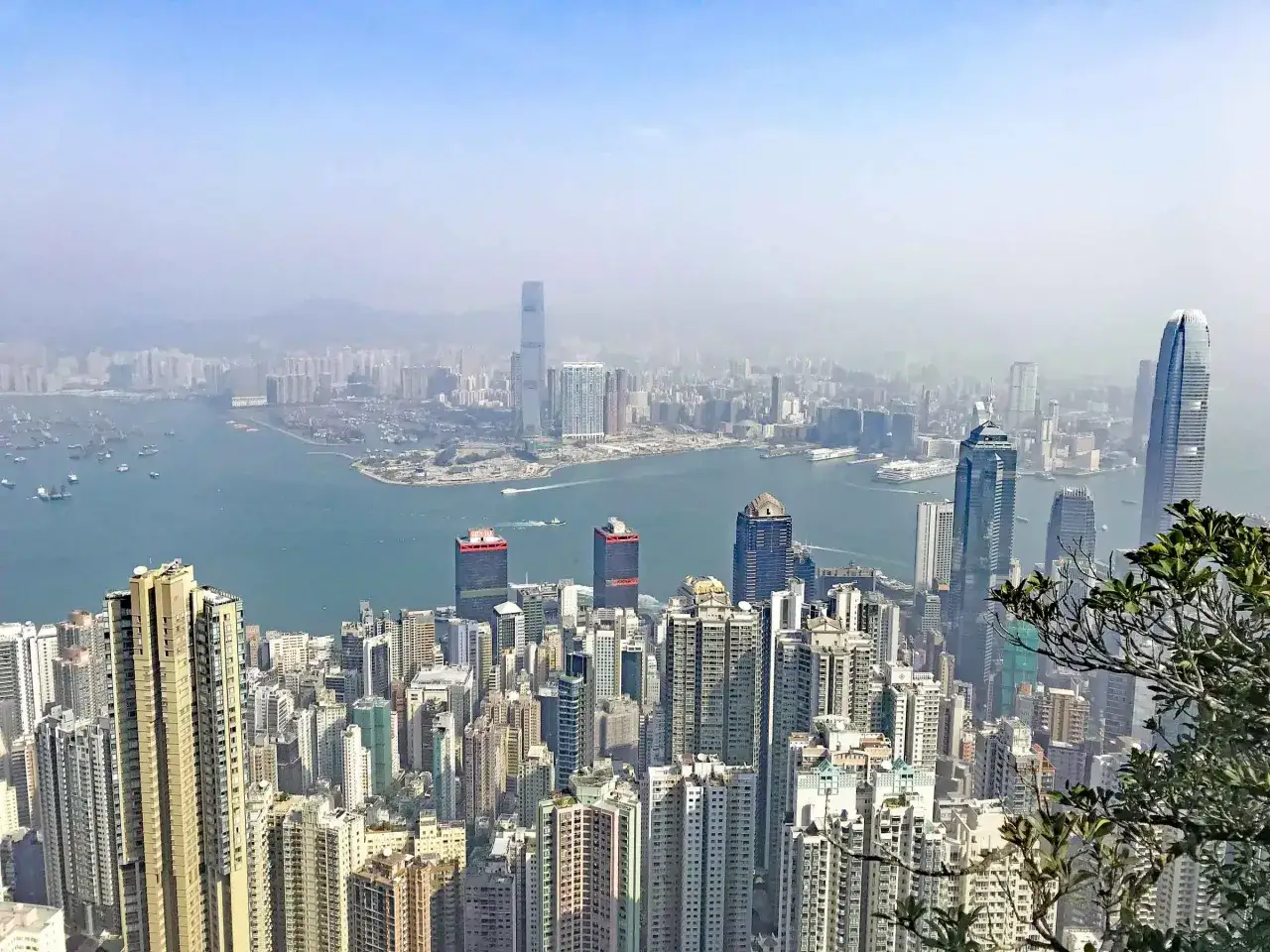 Blick über die Skyline von Hongkong mit dem Hafen und vielen Schiffen. Ein perfekter Ausblick für den Hongkong Urlaub.