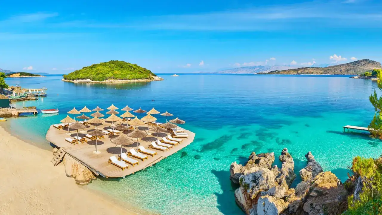 Traumhafter Urlaub in Albanien: T&uuml;rkisblaues Meer, wei&szlig;e Sandstr&auml;nde und Sonnenschirme laden zum Entspannen ein. Ein Paradies f&uuml;r Sonnenanbeter.