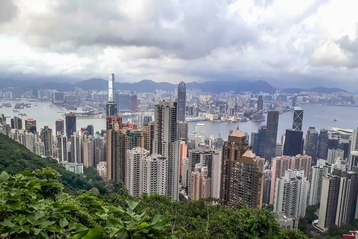 Blick auf die Skyline von Hongkong mit Bergen im Hintergrund. Ein perfekter Ausblick für den Hongkong Urlaub.