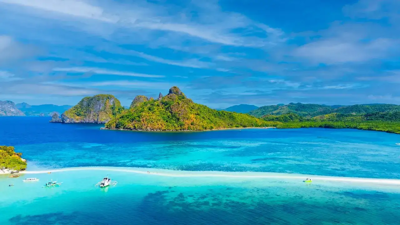 Traumhafte Sandbank und grüne Inseln im türkisfarbenen Meer. Perfekte Philippinen Reisezeit für unvergessliche Ausblicke.