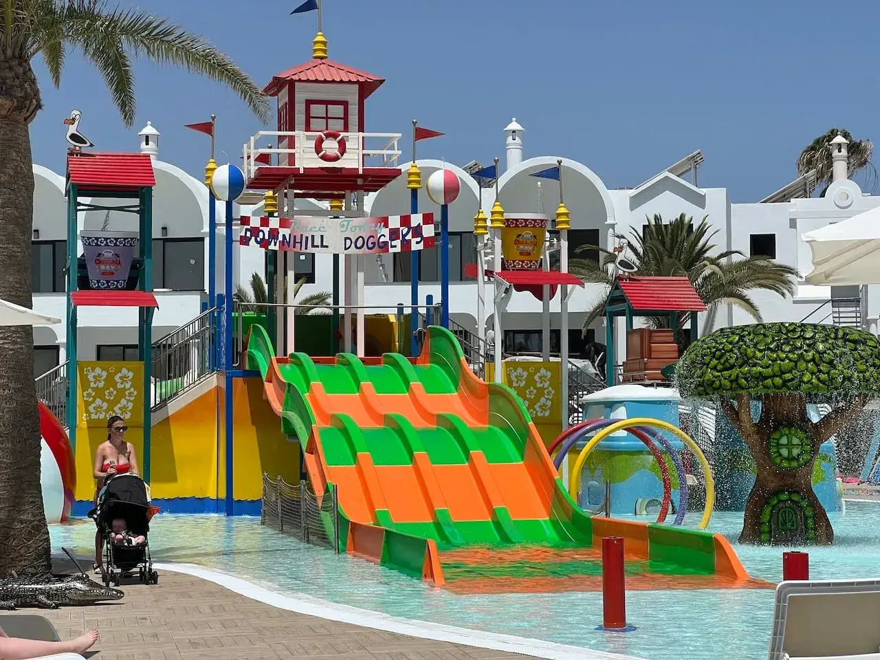 Bunter Wasserrutschen-Spa&szlig; im Bakour Lanzarote Splash Park. Eine Frau schiebt einen Kinderwagen.