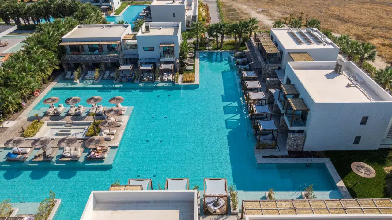 Luxuriöses Resort mit mehreren Pools, Liegen und Sonnenschirmen. Ein idealer Ort für einen entspannten Urlaub am Caravia Beach.