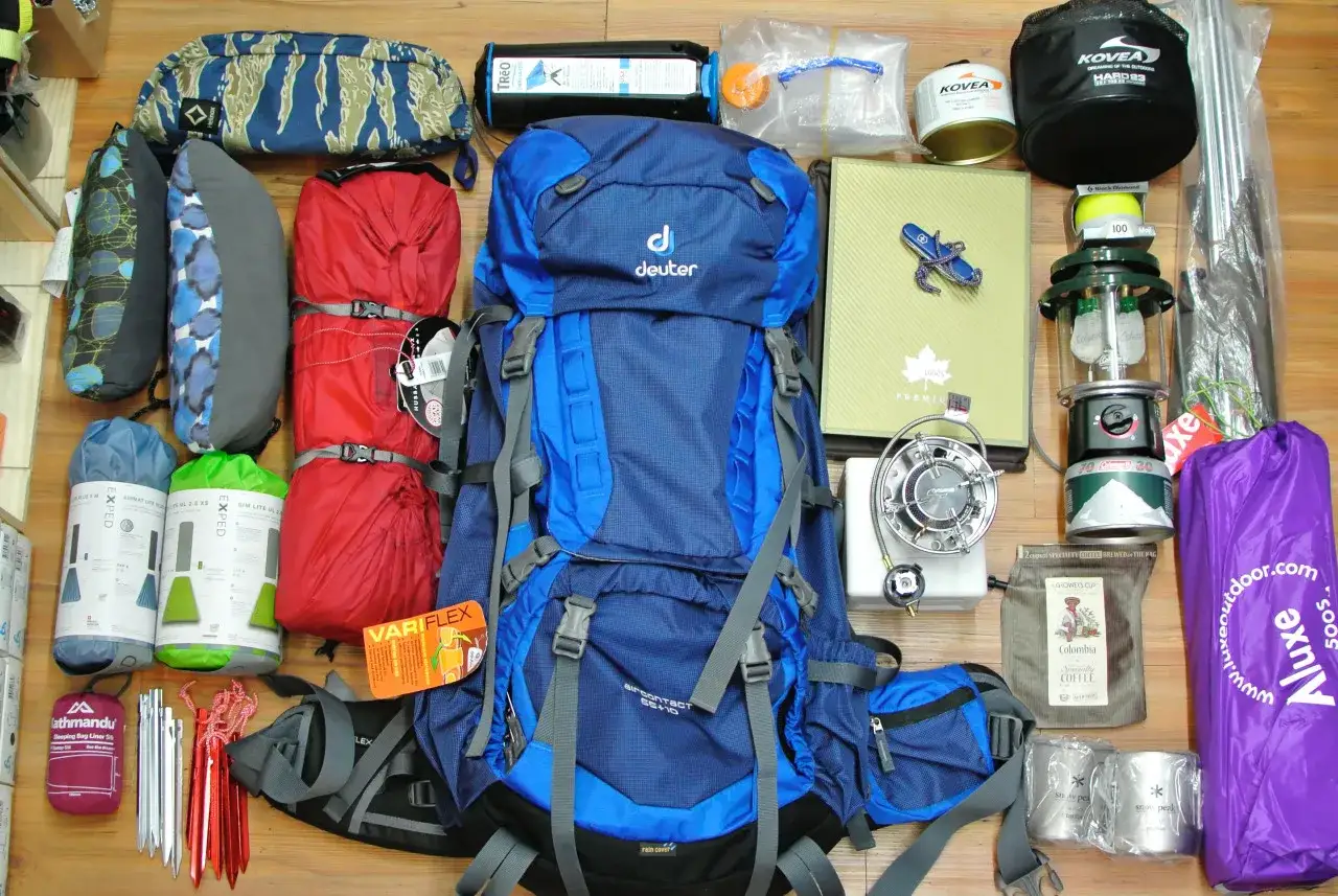 Blauer Rucksack, Schlafsäcke, Kocher, Laterne und weitere nützliche Zelt-Gadgets für Outdoor-Abenteuer.