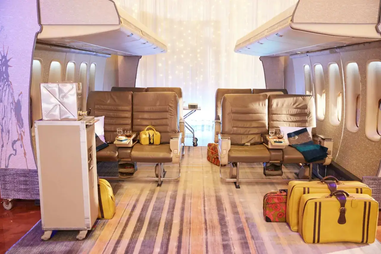 Innenraum eines Jumbo Jet 747 mit Ledersitzen, Gep&auml;ck und Lichterkette.