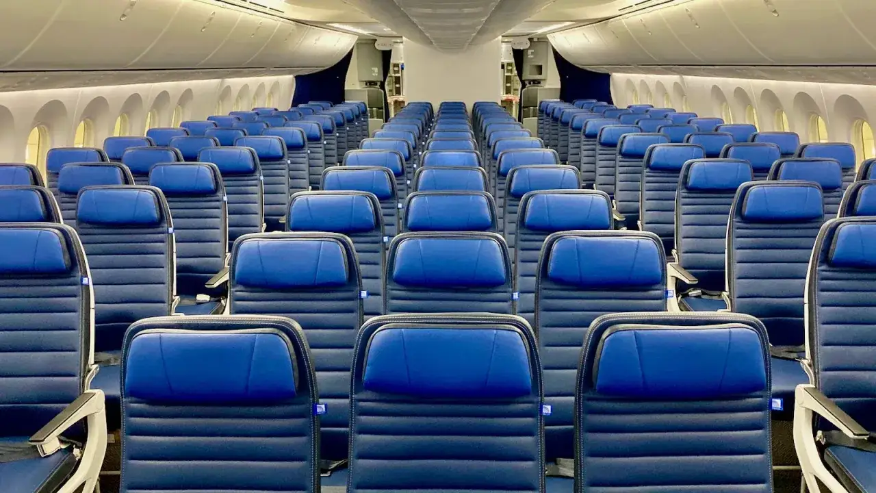 Leere blaue Flugzeugsitze. Wo sitzt man im Flugzeug am besten? Die Gänge bieten mehr Beinfreiheit, Fensterplätze Privatsphäre.
