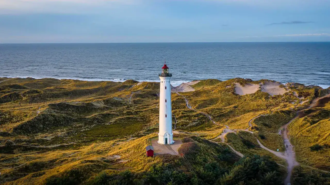 Leuchtturm auf den Hvide Sande Dünen, mit dem Meer im Hintergrund.