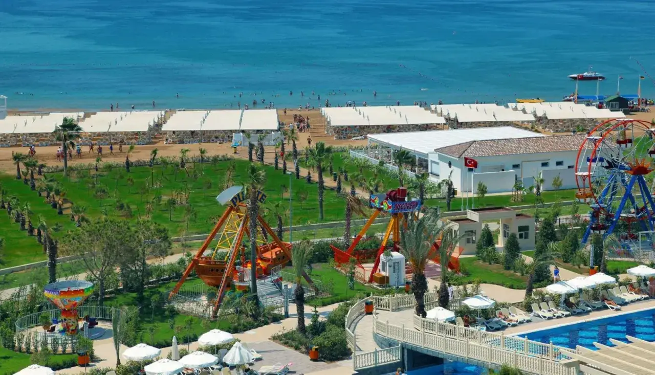 Ein Ferienresort am Meer mit Strand, Pool und Fahrgeschäften, das an den royal alhambra palace erinnert.
