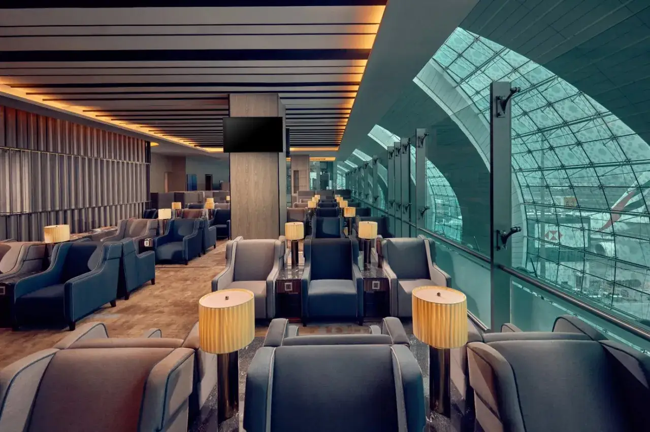 Elegante Lounge im Flughafen Dubai innen mit bequemen Sesseln und Blick auf die Glasfassade.
