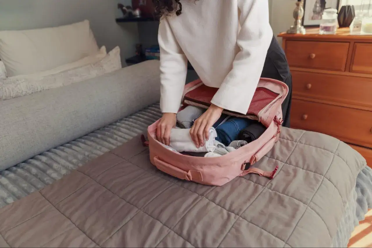 Packliste Thailand: Kleidung wird in einen rosa Rucksack gepackt, bereit für die Reise.