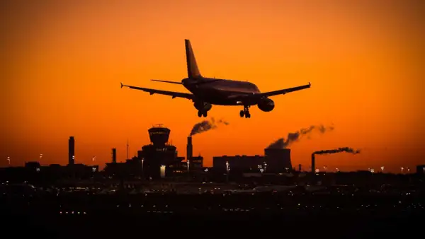 Flugzeug landet bei Sonnenuntergang in Deutschland. Tipps gegen Jetlag USA nach Deutschland: Anpassung der Schlafenszeiten.