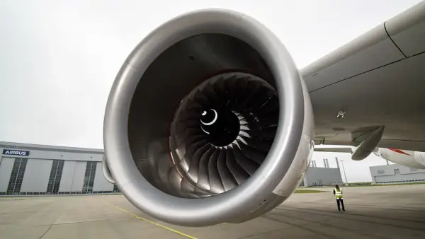 Detailaufnahme eines riesigen Triebwerks der A380. Im Hintergrund die Airbus-Halle und eine Person in Warnweste.