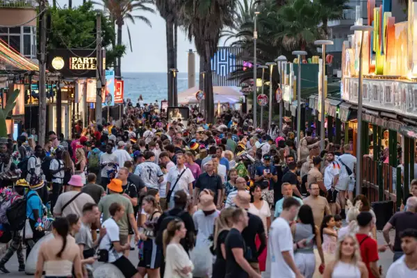 Volle Promenade auf Mallorca, viele Menschen unterwegs. Die Tourismussteuer auf Mallorca wird diskutiert, während Urlauber das Nachtleben genießen.