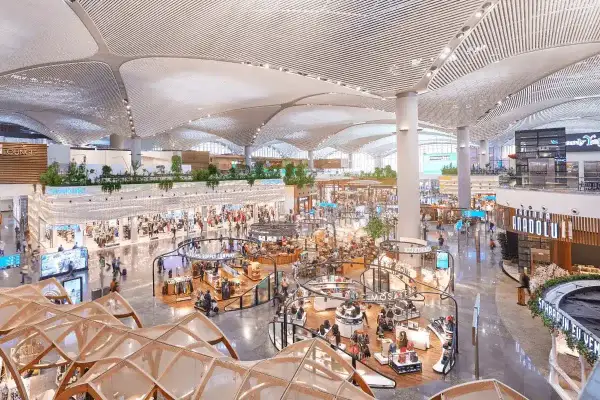 Helle, moderne Einkaufsbereiche im Istanbul Flughafen mit vielen Geschäften und Menschen.