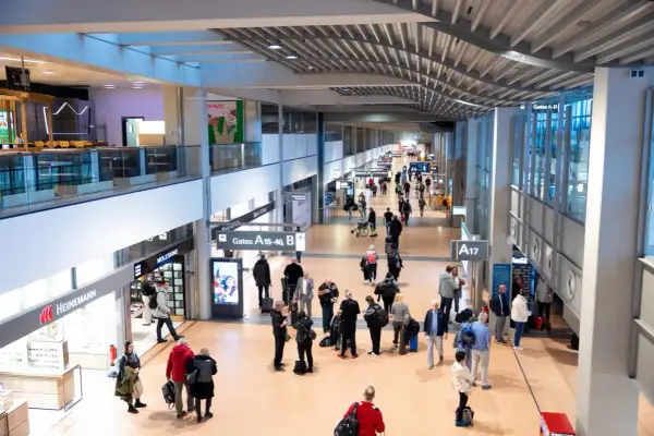 Menschen im Hamburger Flughafen, einige eilen zu ihren Gates, andere suchen nach Möglichkeiten, Geld zu wechseln.