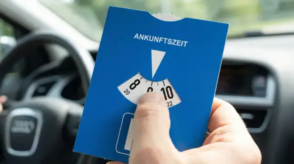 Blaue Parkscheibe mit Ankunftszeit-Einstellung im Auto. Beachten Sie die Regeln zum Parken mit Parkscheibe nach 18 Uhr.