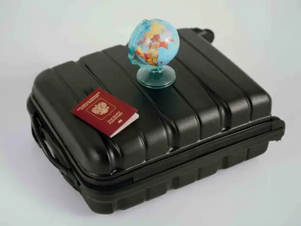 Reisekoffer mit Reisepass und Globus. Wo kann man Geld wechseln? Am Flughafen oder in der Bank.