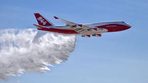 Eine Boeing 747, die als Global Supertanker zur Brandbekämpfung eingesetzt wird, sprüht Wasser. Sie fliegt schnell, um Brände zu löschen.