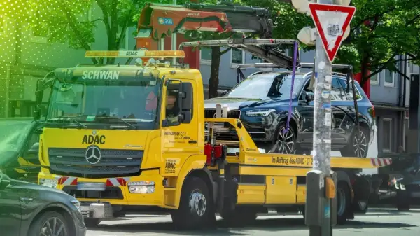 Gelber ADAC Abschleppwagen mit dunklem SUV auf der Ladefläche in Berlin. Informiert über die Kosten für Abschleppen in Berlin.
