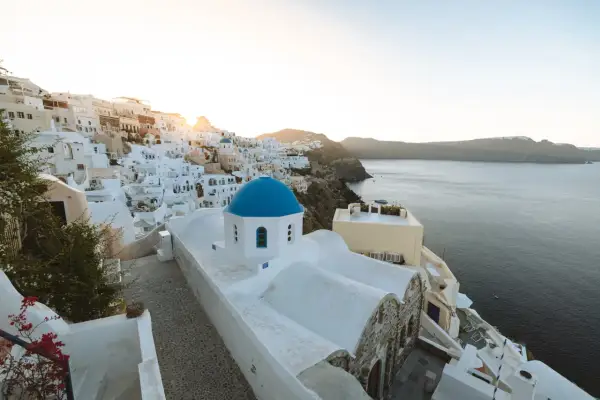 Ein malerischer Blick auf Oia, Santorini, mit seinen weiß getünchten Häusern und der ikonischen blauen Kuppelkirche. Perfekt für einen Santorini Urlaub.