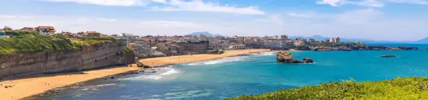 Traumhafter Frankreich Urlaub am Meer: Küstenstadt mit Sandstrand, Felsen und türkisfarbenem Wasser.