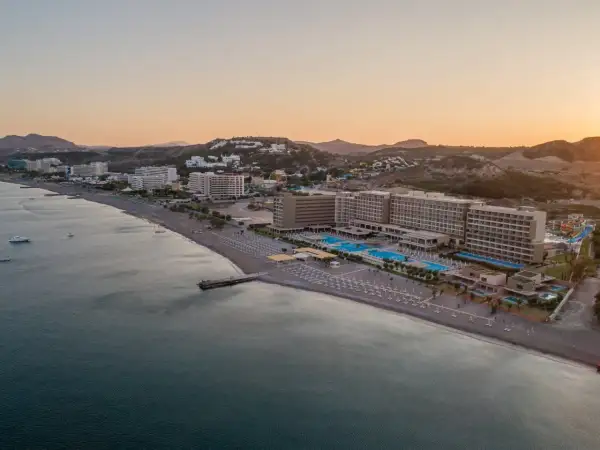 Amada Colossos Resort Rhodos: Weitläufige Hotelanlage mit Pools und Strand am Meer, umgeben von Hügeln.