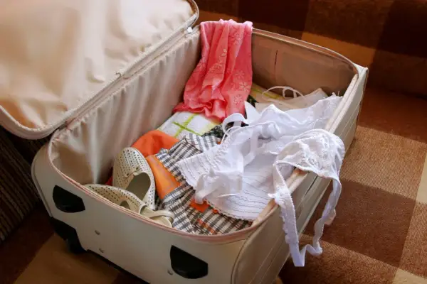 Koffer packen tipps knitterfrei: Kleidung, Schuhe und Wäsche liegen bereit.