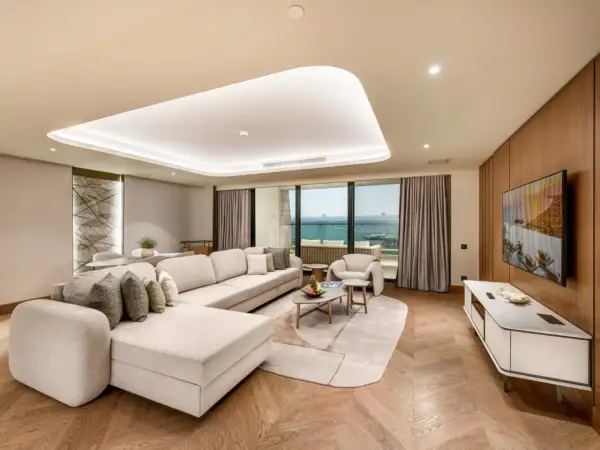 Luxuriöses Wohnzimmer mit Meerblick im Regnum The Crown Belek. Ein großes Ecksofa lädt zum Entspannen ein.