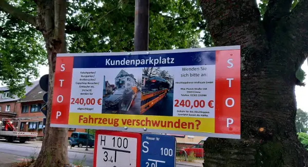 Schild warnt vor hohen **Abschleppkosten ohne Abschleppen** bei Falschparken auf Kundenparkplatz. 240€ Strafe!