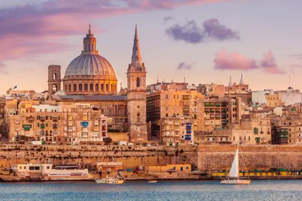Sonnenuntergang über Valletta, Malta. Die Kuppel der St. Paul's Cathedral und die St. John's Co-Cathedral dominieren die Skyline. Ein perfekter Ort für einen Urlaub.